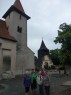 V Malíně před dřevěnou zvonicí a kostelem